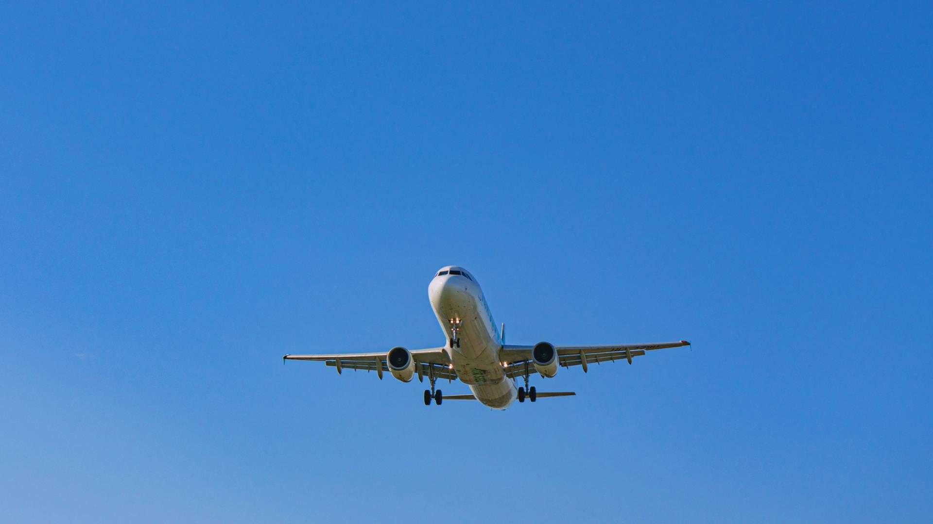Commercial airplane ascending into a clear blue sky