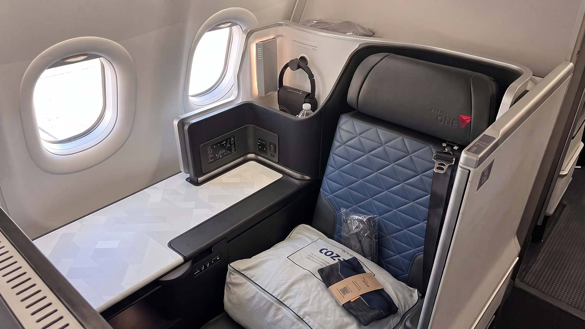 Delta One Suite seat with sliding door and bedding