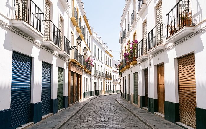 An empty Seville street at three in the afternoon in August with every shutter down