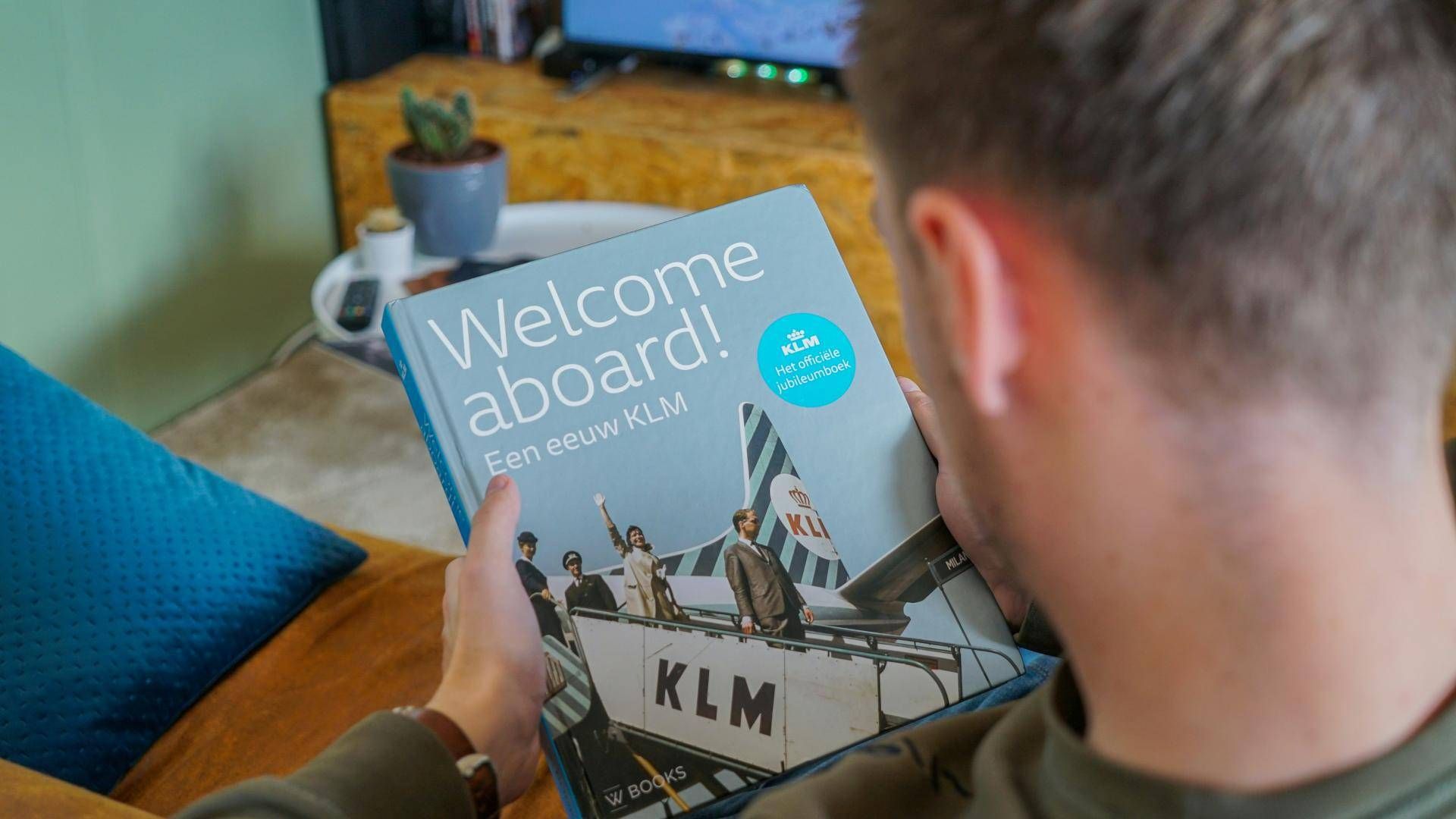 Passenger reading the KLM Welcome Aboard inflight magazine